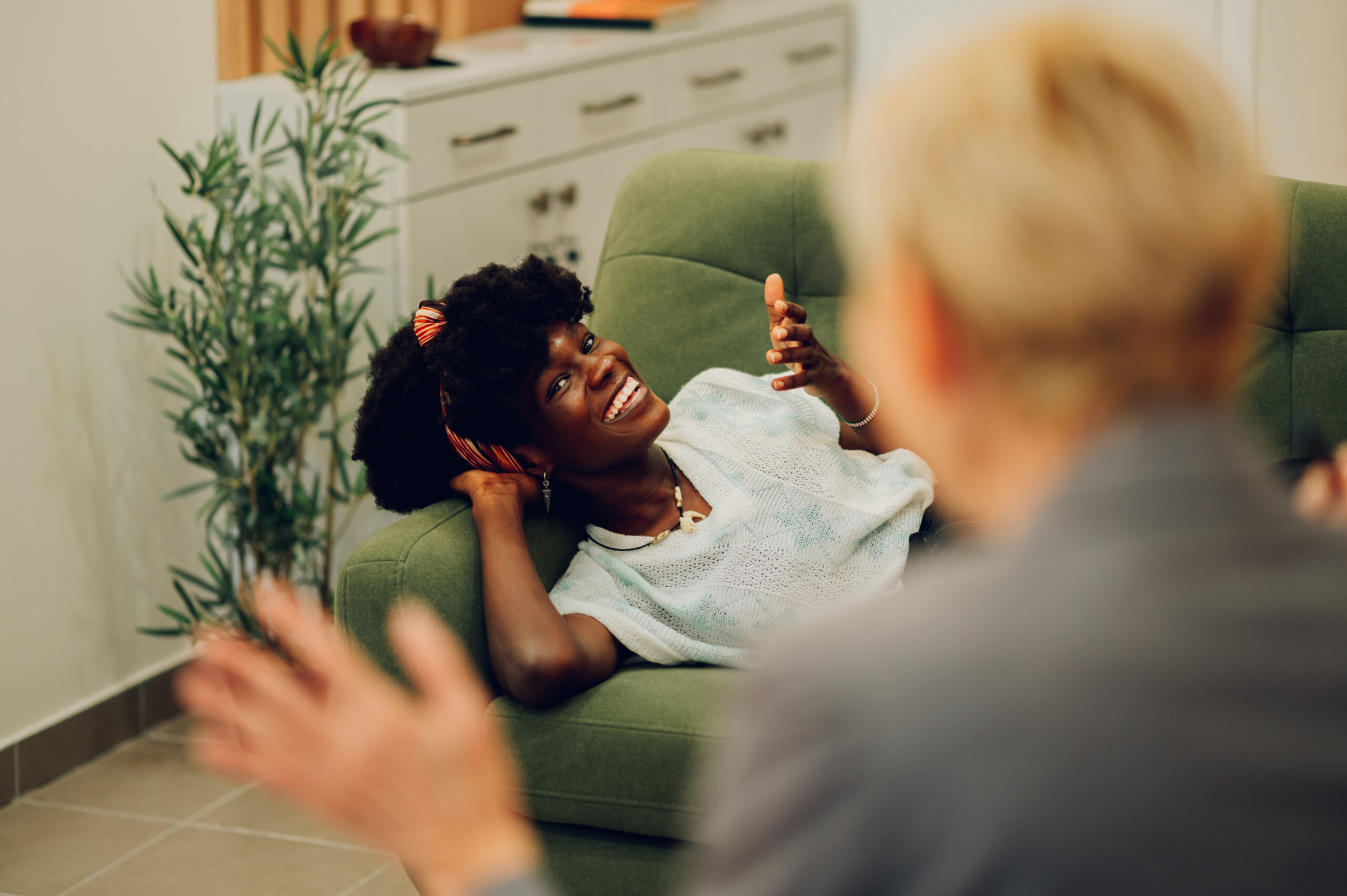 Woman is lying on the couch at a psychotherapist's office and having an individual session.